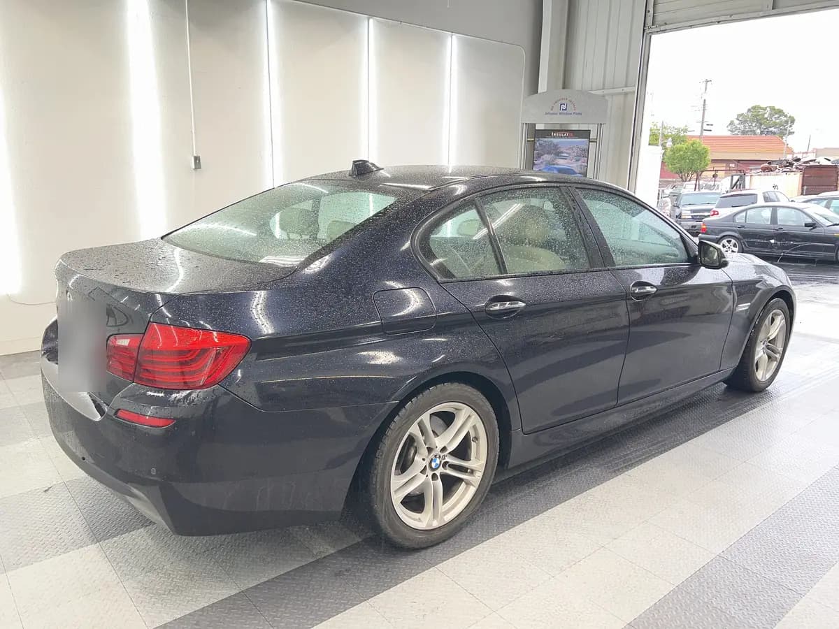 Blue BMW 5 Series before window tinting, factory glass (view 1)