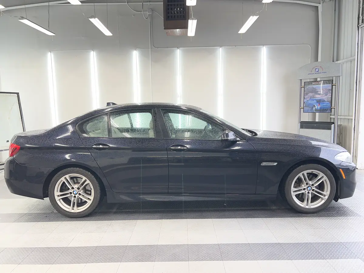 Blue BMW 5 Series before window tinting, factory glass (view 2)