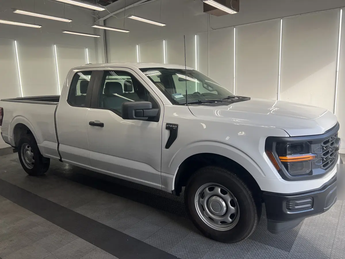 White Ford F-150 before window tinting, factory glass (view 1)