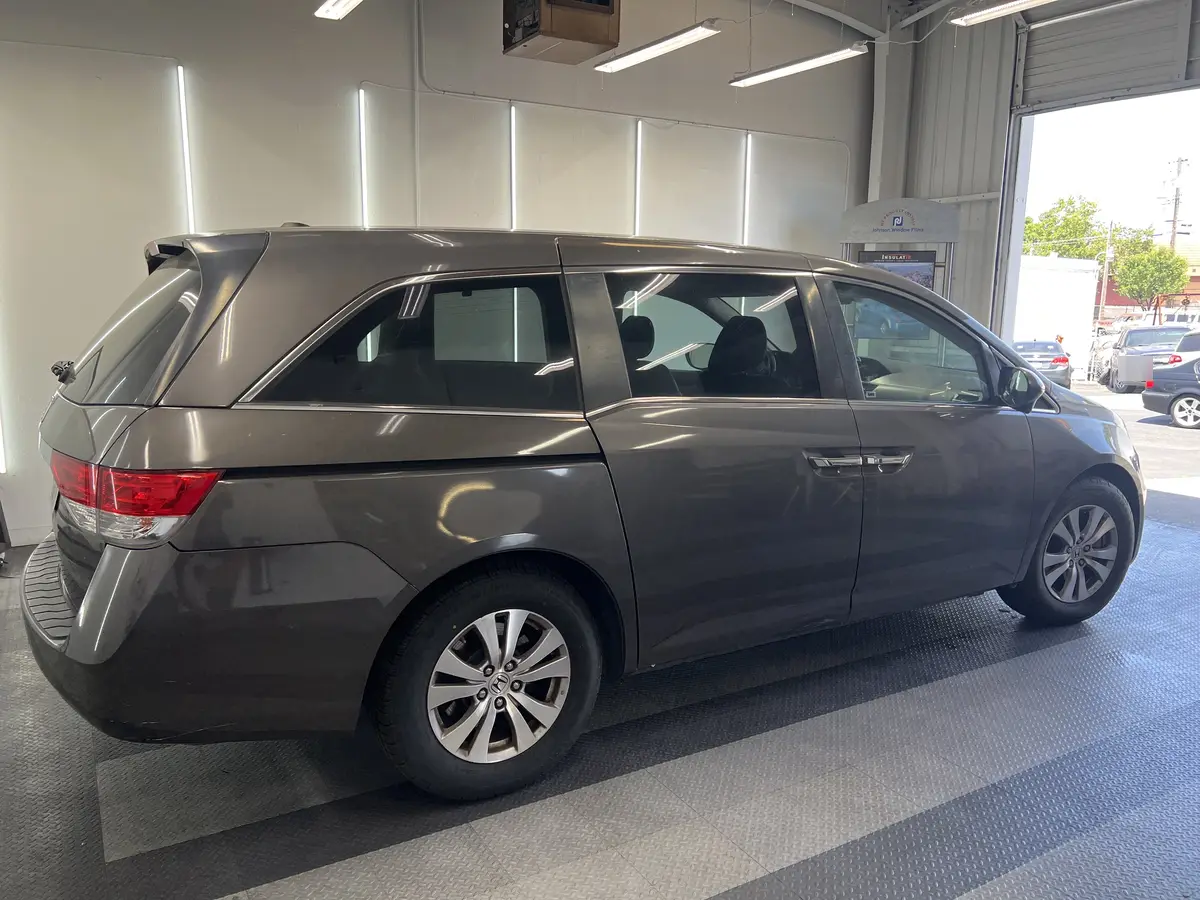 Gray Honda Odyssey before window tinting, factory glass (view 1)