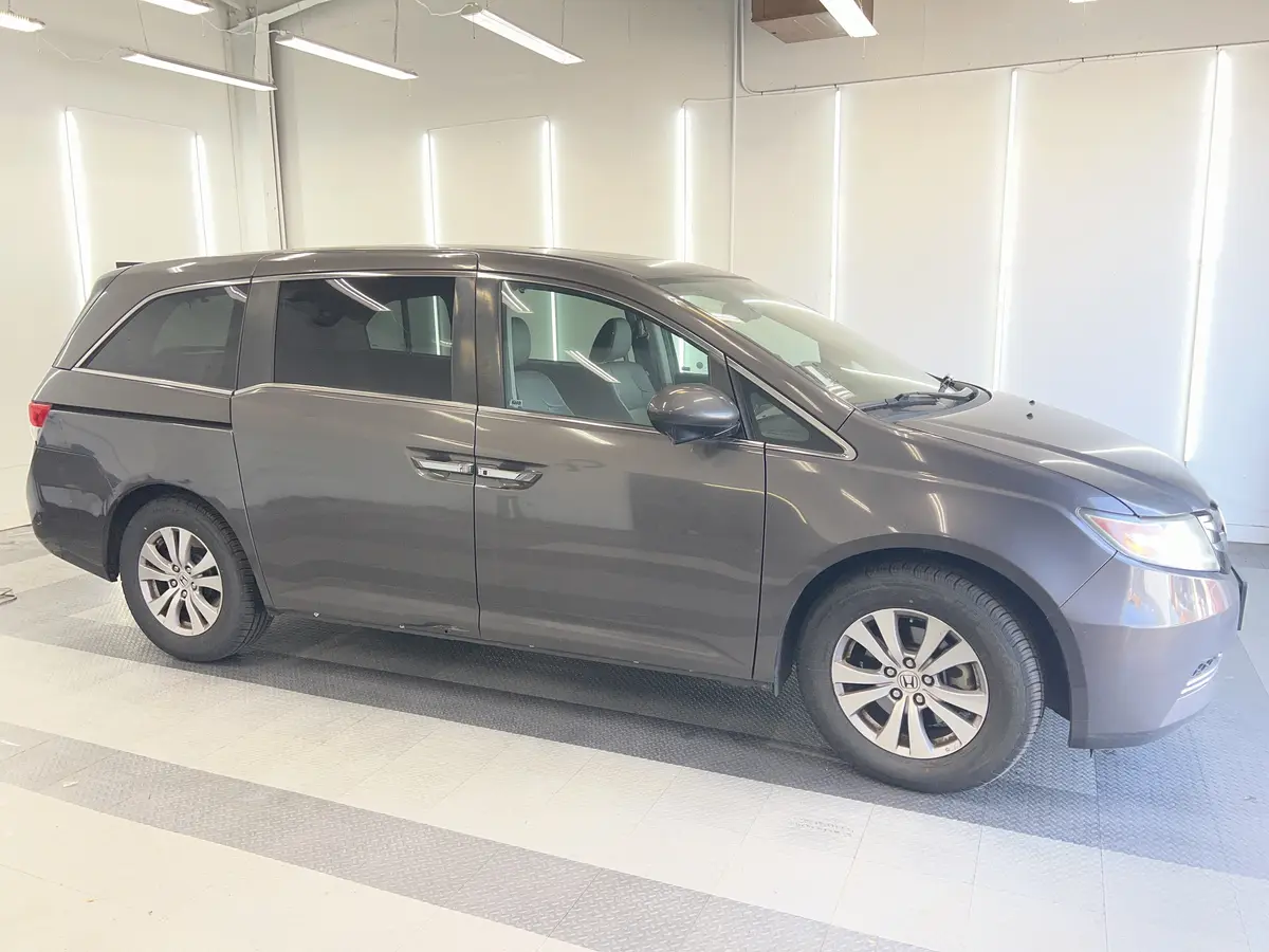 Gray Honda Odyssey before window tinting, factory glass (view 3)