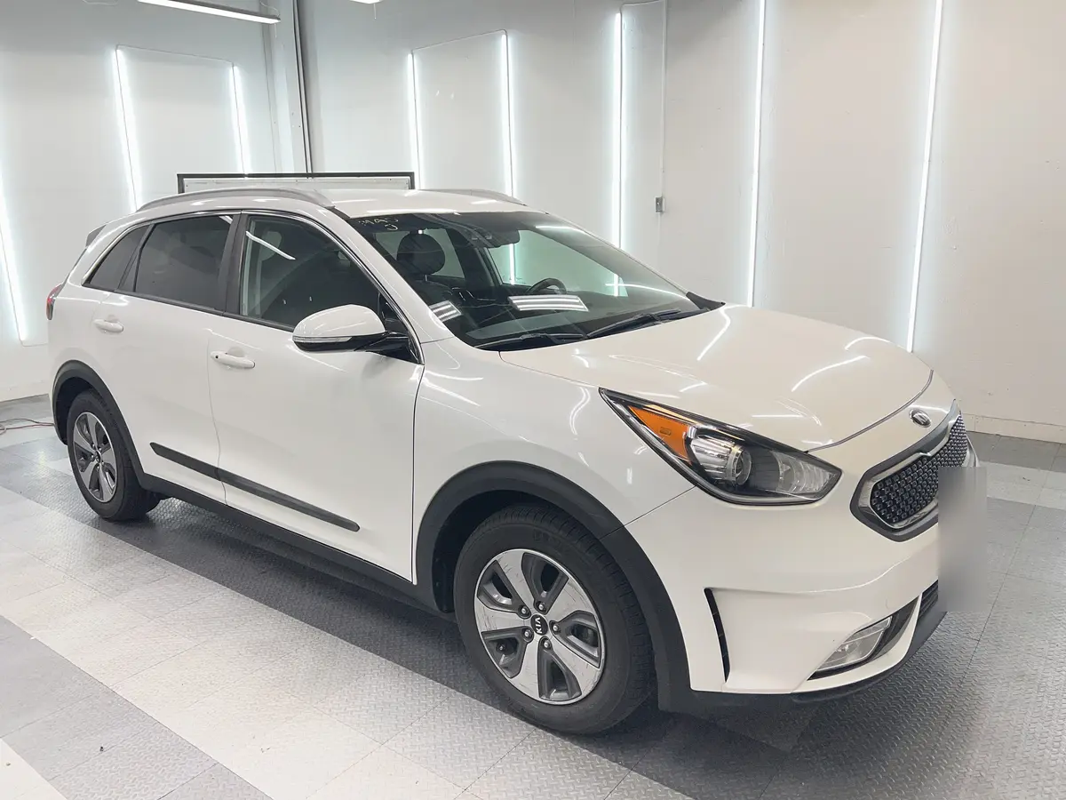 White Kia Niro before window tinting, factory glass (view 1)