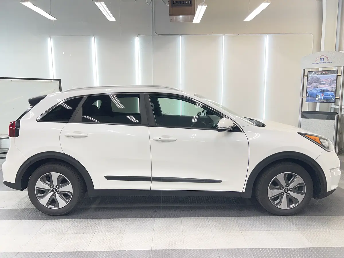 White Kia Niro before window tinting, factory glass (view 2)