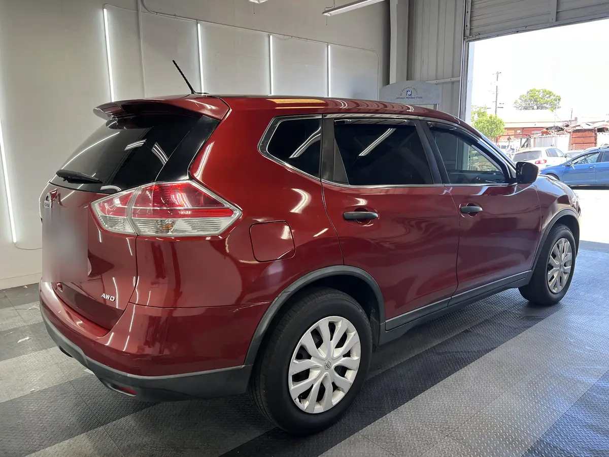 Red Nissan Rogue after Avery Dennison Encore carbon window tint (view 3)
