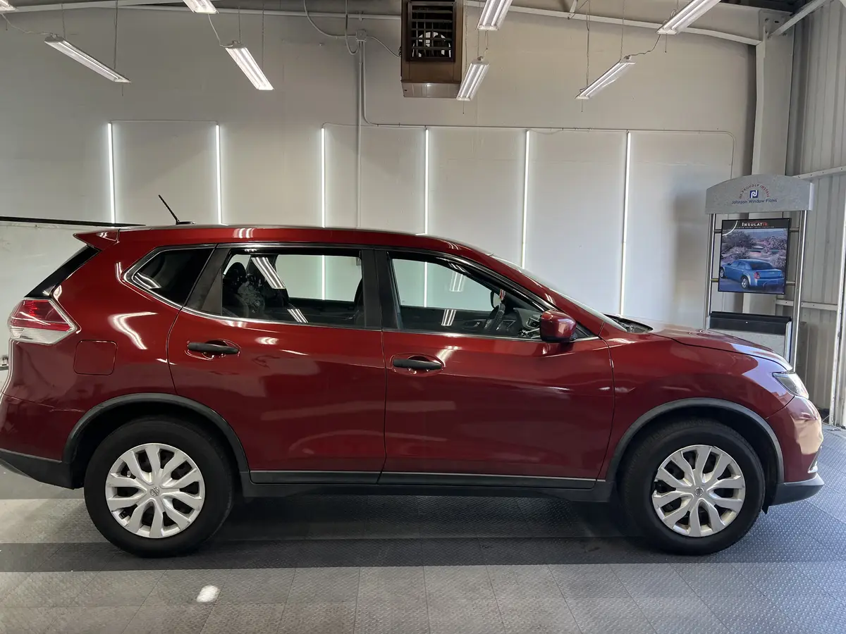 Red Nissan Rogue before window tinting, factory glass (view 2)