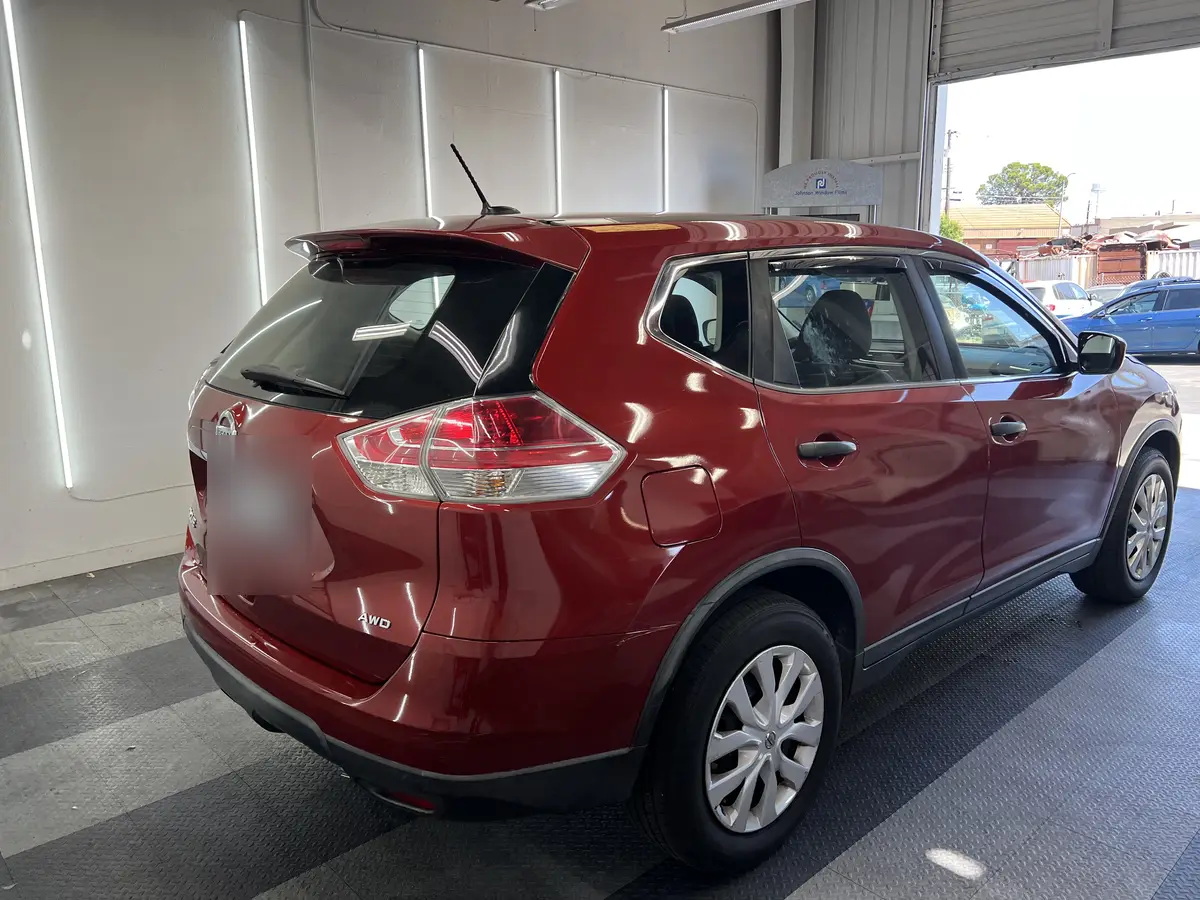 Red Nissan Rogue before window tinting, factory glass (view 3)