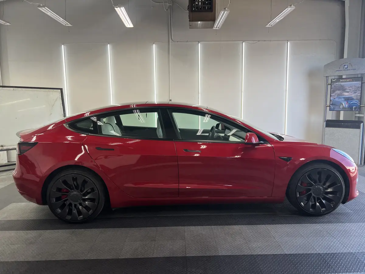 Red Tesla Model 3 before window tinting, factory glass (view 2)
