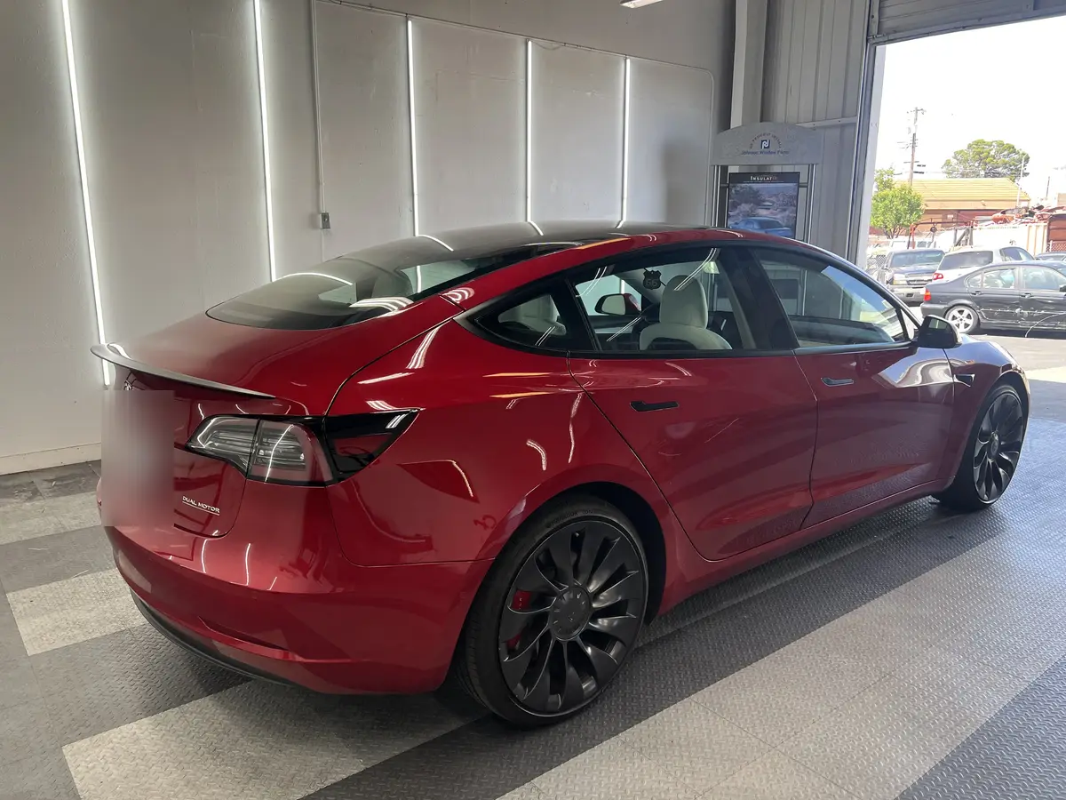 Red Tesla Model 3 before window tinting, factory glass (view 3)