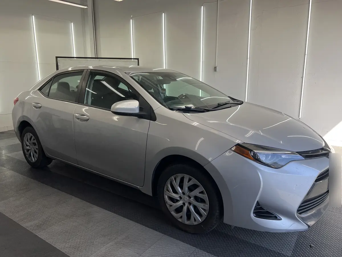 Silver Toyota Corolla before window tinting, factory glass (view 1)