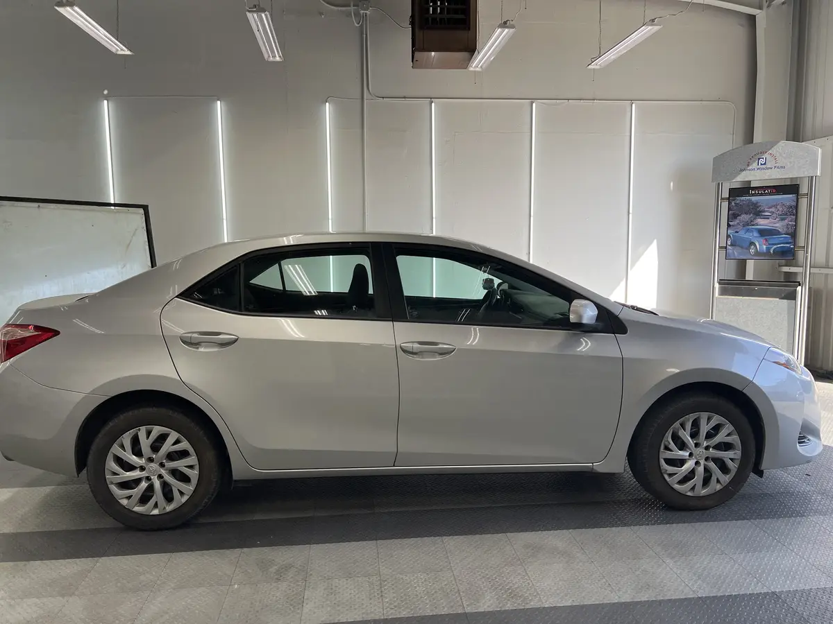 Silver Toyota Corolla before window tinting, factory glass (view 2)