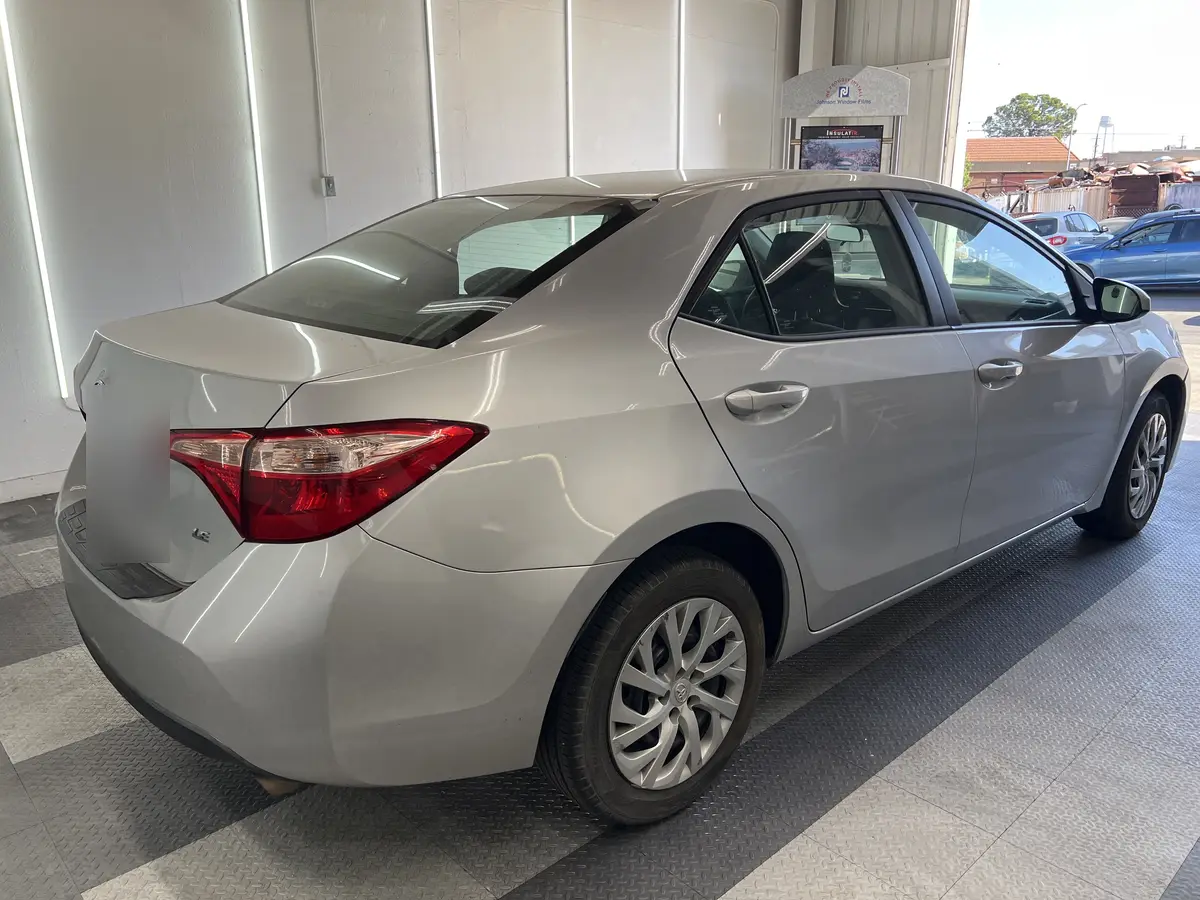 Silver Toyota Corolla before window tinting, factory glass (view 3)