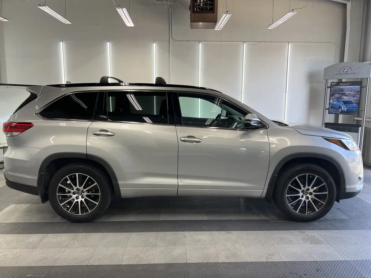 Silver Toyota Highlander before window tinting, factory glass (view 1)