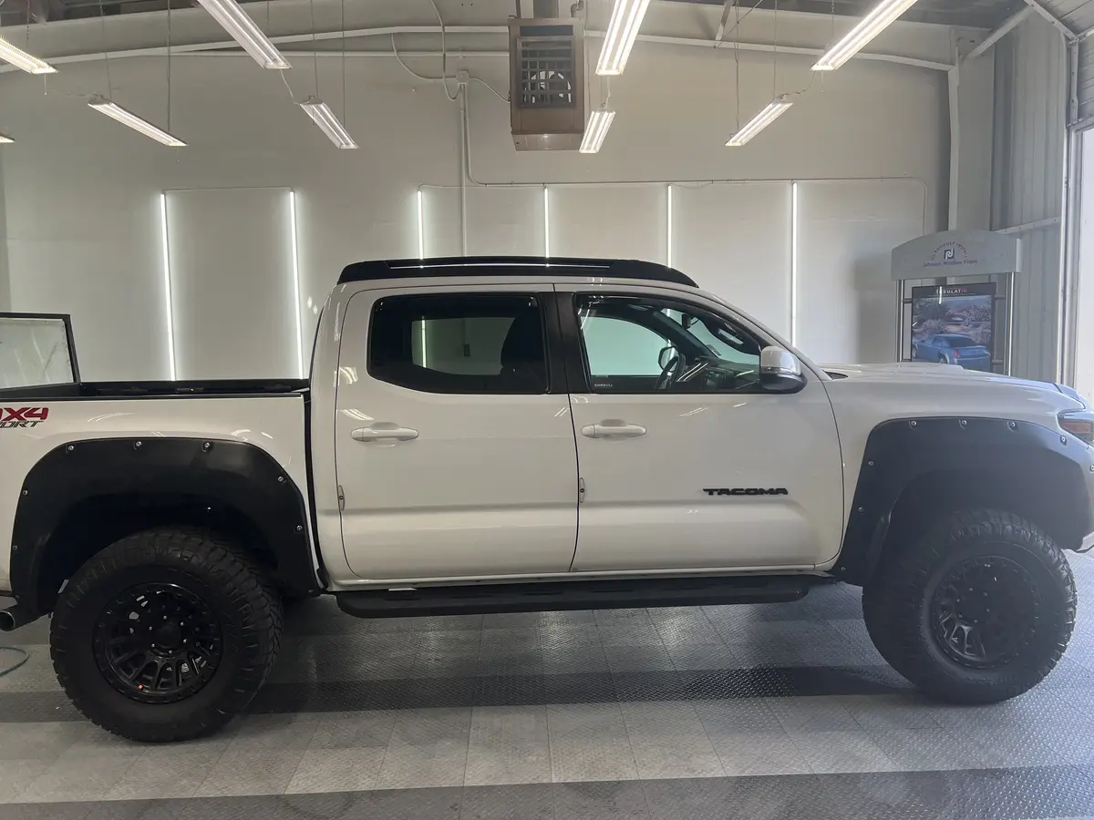 White Toyota Tacoma before window tinting, factory glass (view 1)