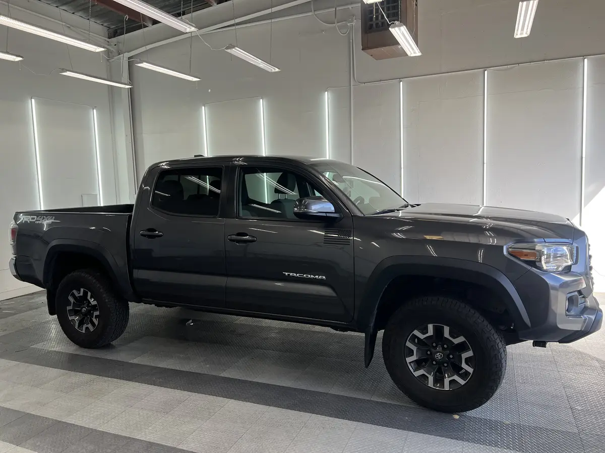 Gray Toyota Tacoma before window tinting, factory glass (view 1)