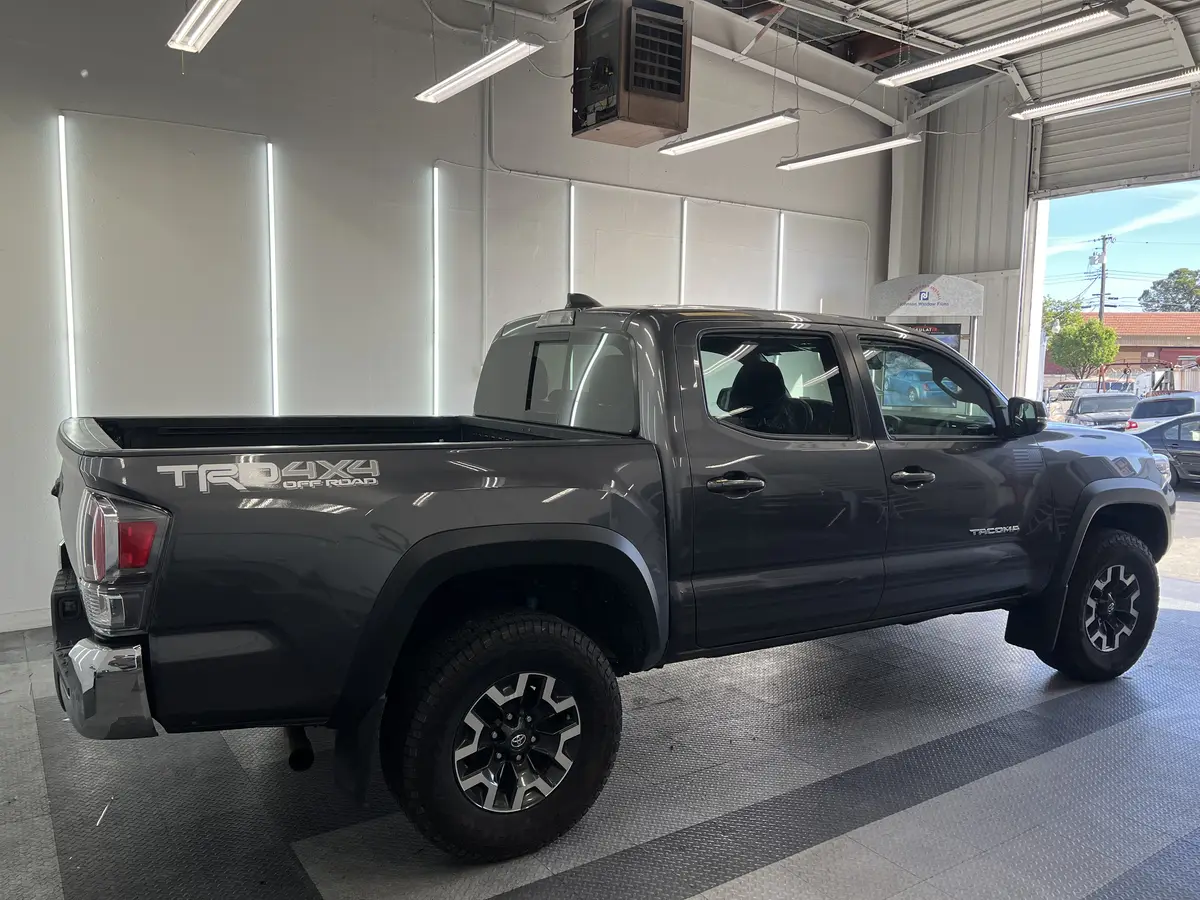 Gray Toyota Tacoma before window tinting, factory glass (view 2)