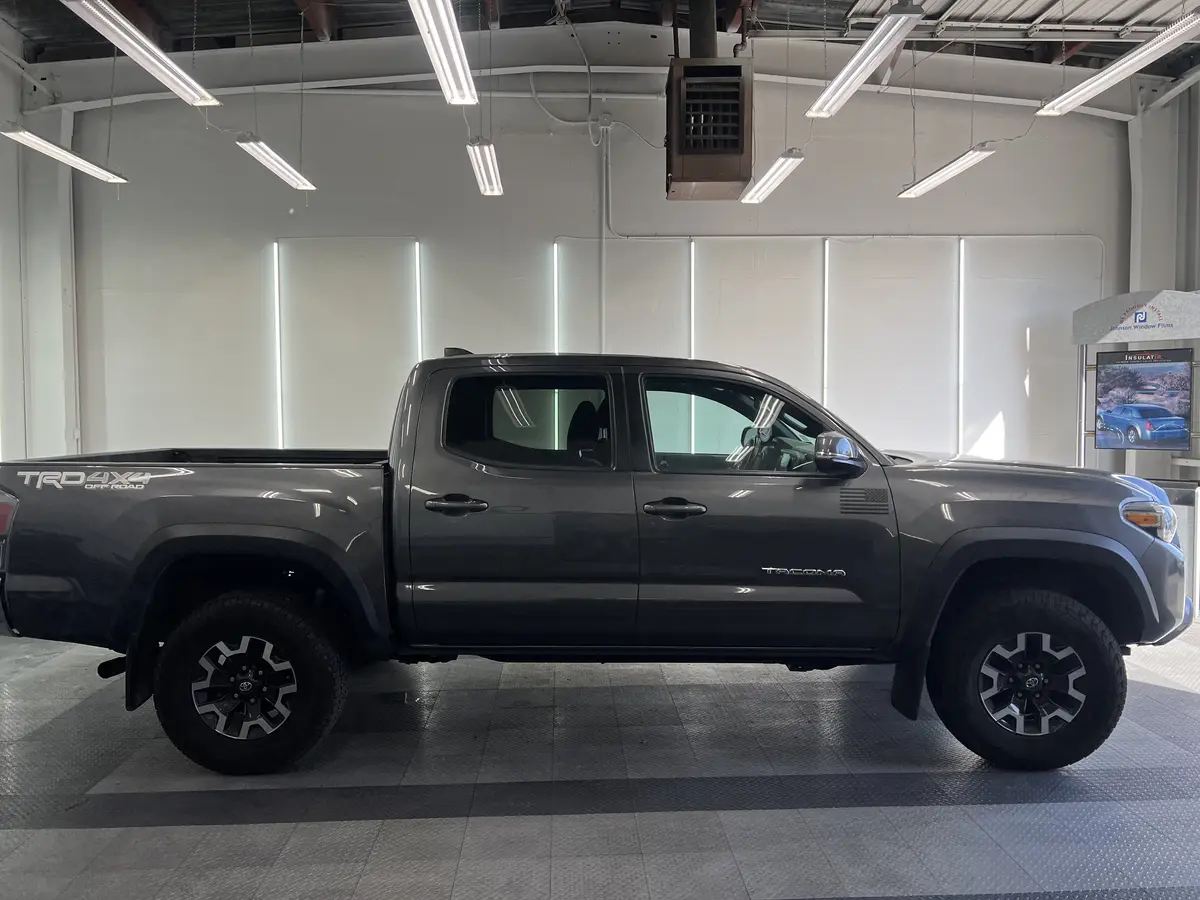 Gray Toyota Tacoma before window tinting, factory glass (view 3)