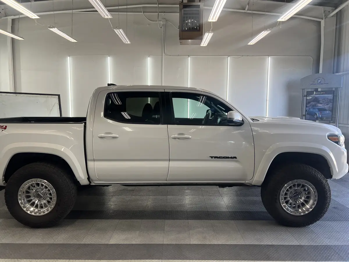 White Toyota Tacoma before window tinting, factory glass (view 1)