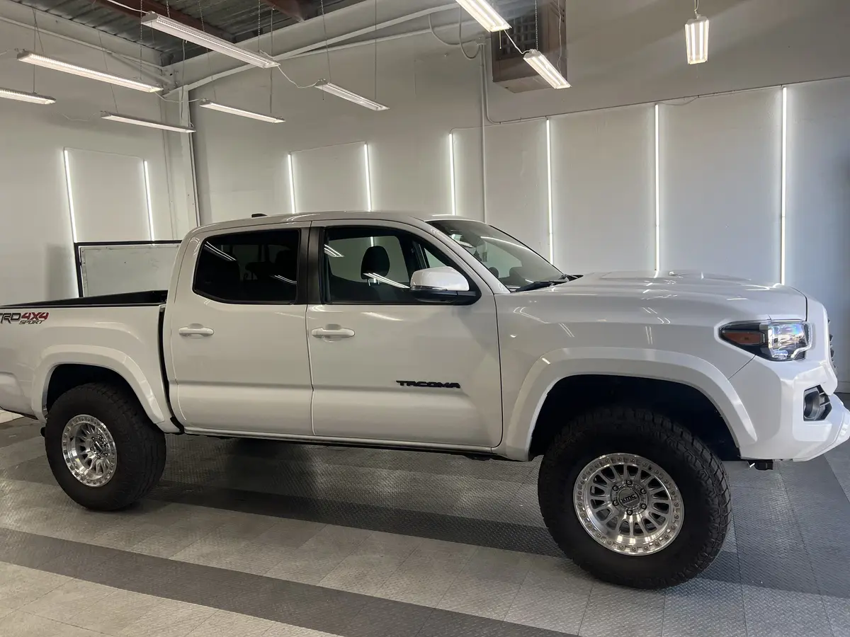White Toyota Tacoma before window tinting, factory glass (view 2)