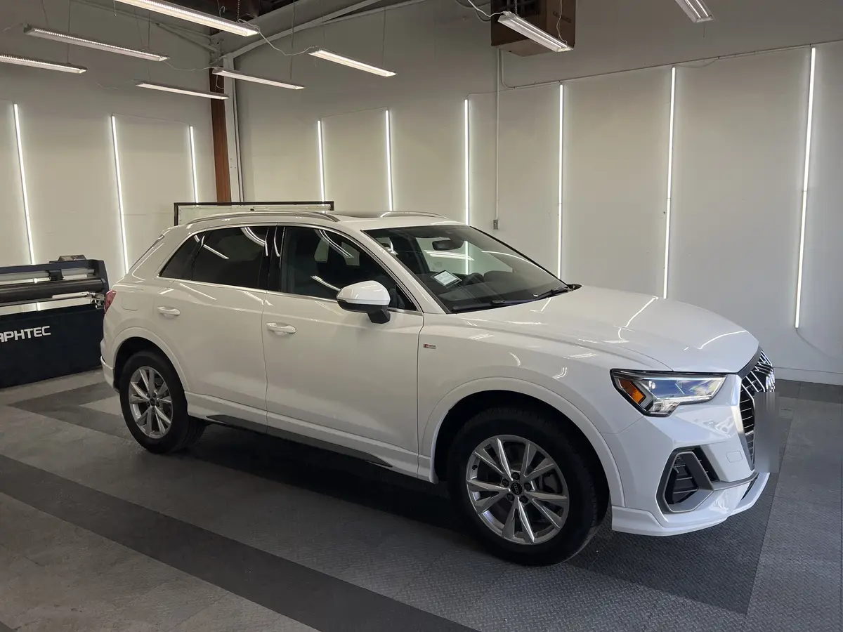 White Audi Q3 before window tinting, factory glass (view 1)