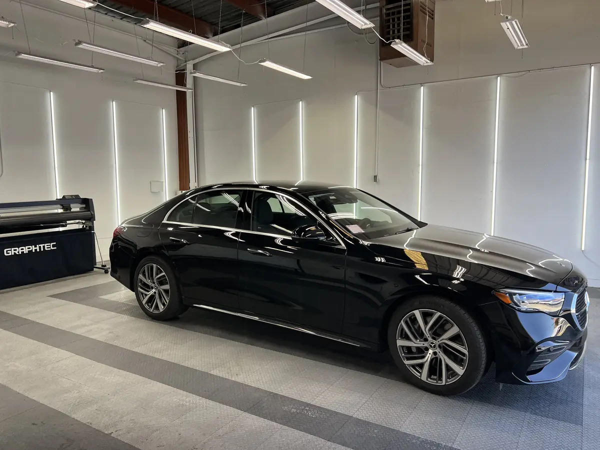 Black Mercedes-Benz E-Class before window tinting, factory glass (view 1)