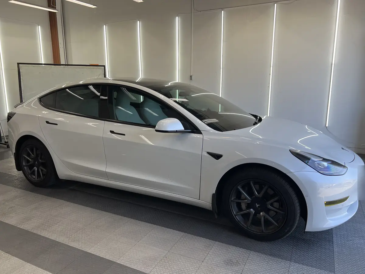 White Tesla Model 3 before window tinting, factory glass (view 1)