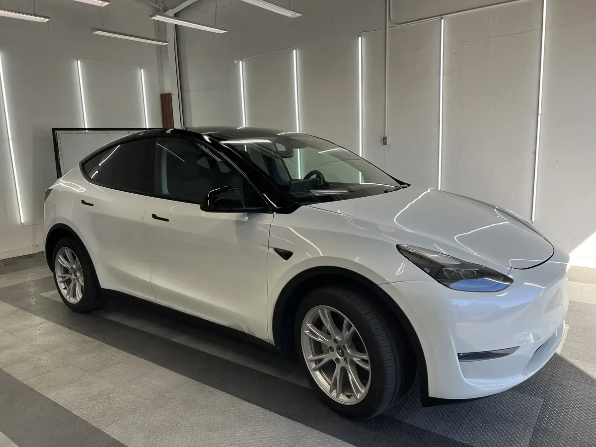 White Tesla Model Y before window tinting, factory glass (view 1)