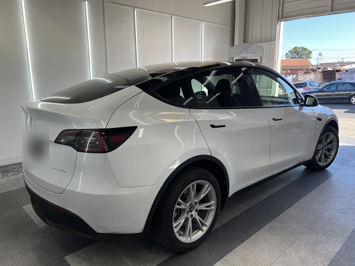 White Tesla Model Y before window tinting, factory glass (view 3)