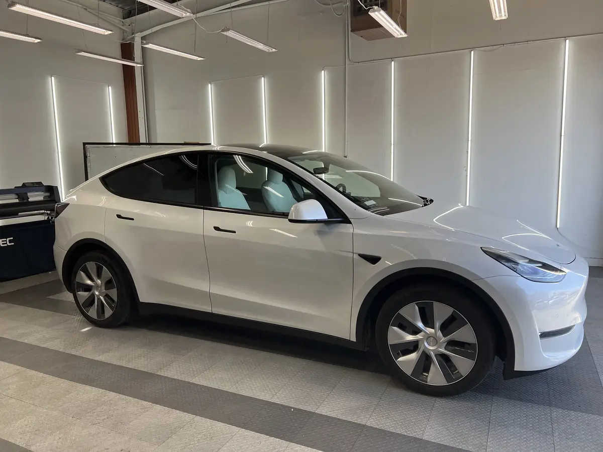 White Tesla Model Y before window tinting, factory glass (view 1)