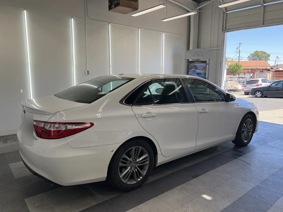 White Toyota Camry before window tinting, factory glass (view 2)