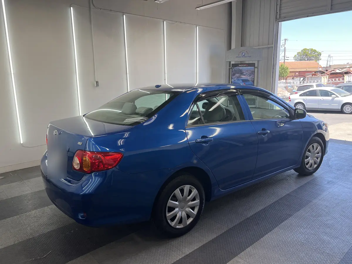 Blue Toyota Corolla before window tinting, factory glass (view 3)