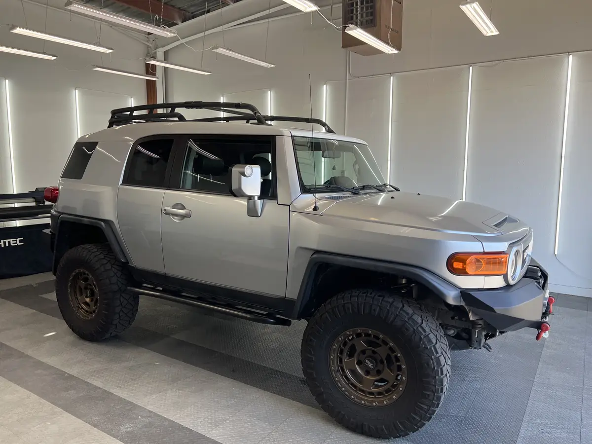 Silver Toyota FJ Cruiser before window tinting, factory glass (view 1)