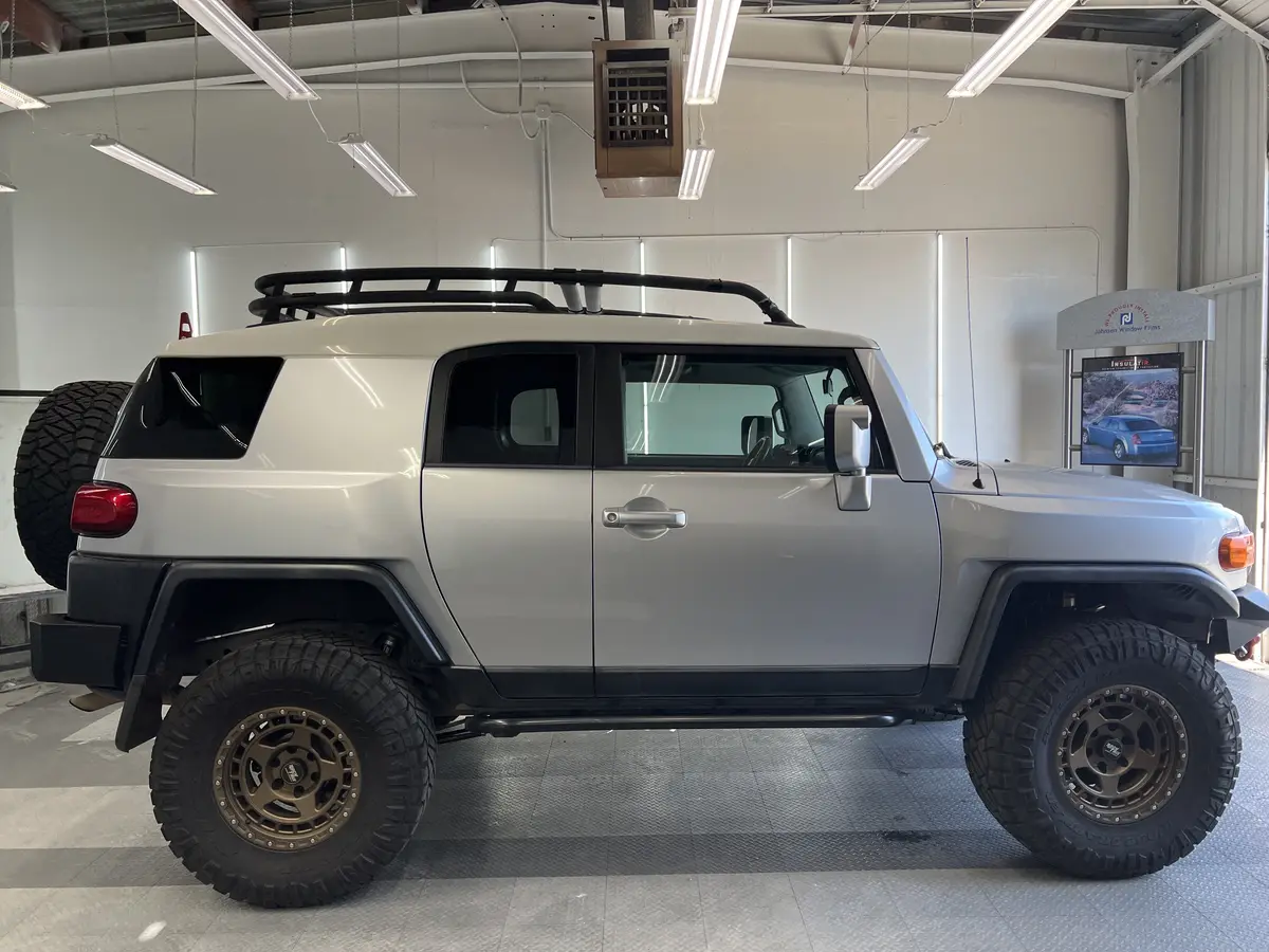 Silver Toyota FJ Cruiser before window tinting, factory glass (view 3)