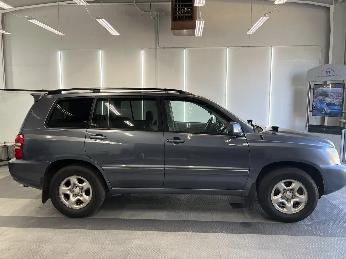 Gray Toyota Highlander before window tinting, factory glass (view 1)