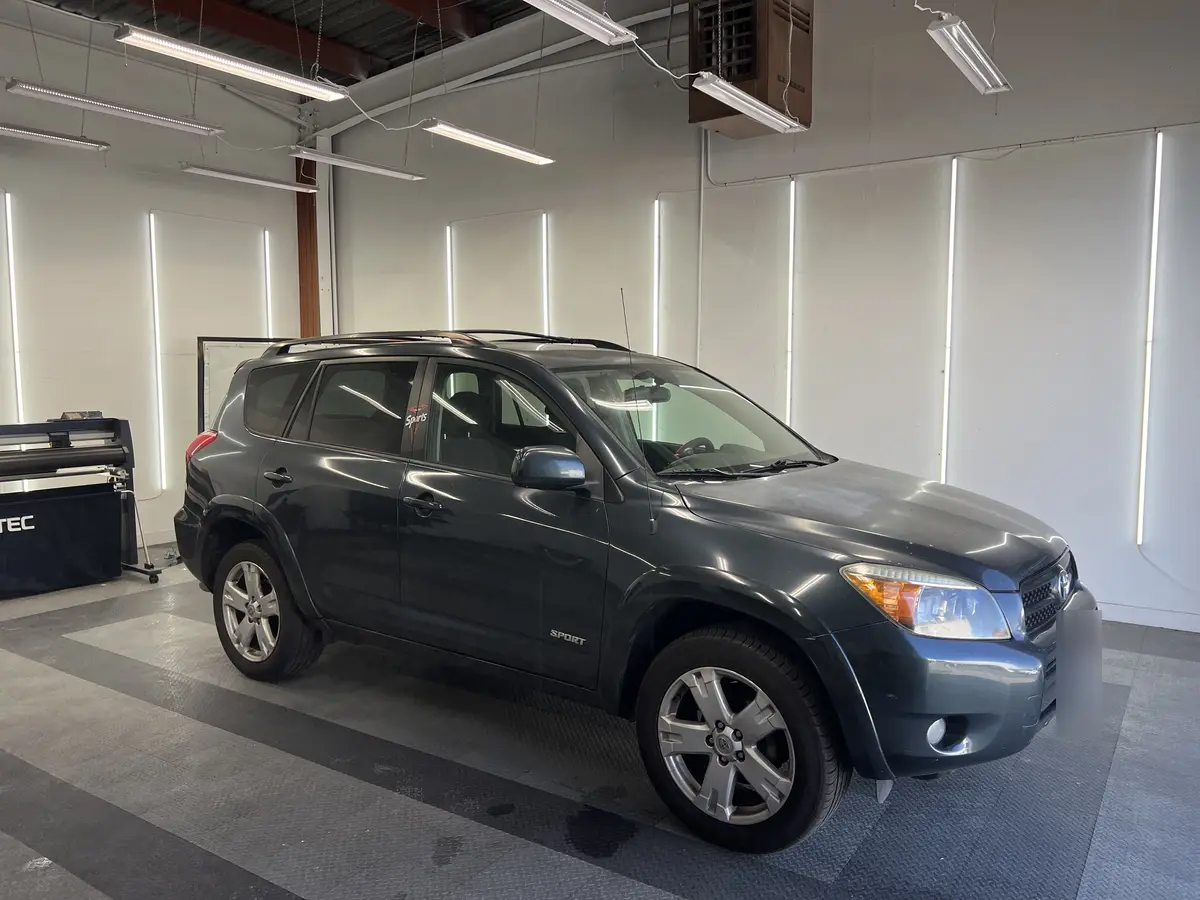 Gray Toyota RAV4 before window tinting, factory glass (view 2)