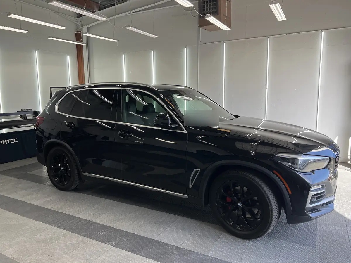 Black BMW X5 before window tinting, factory glass (view 1)