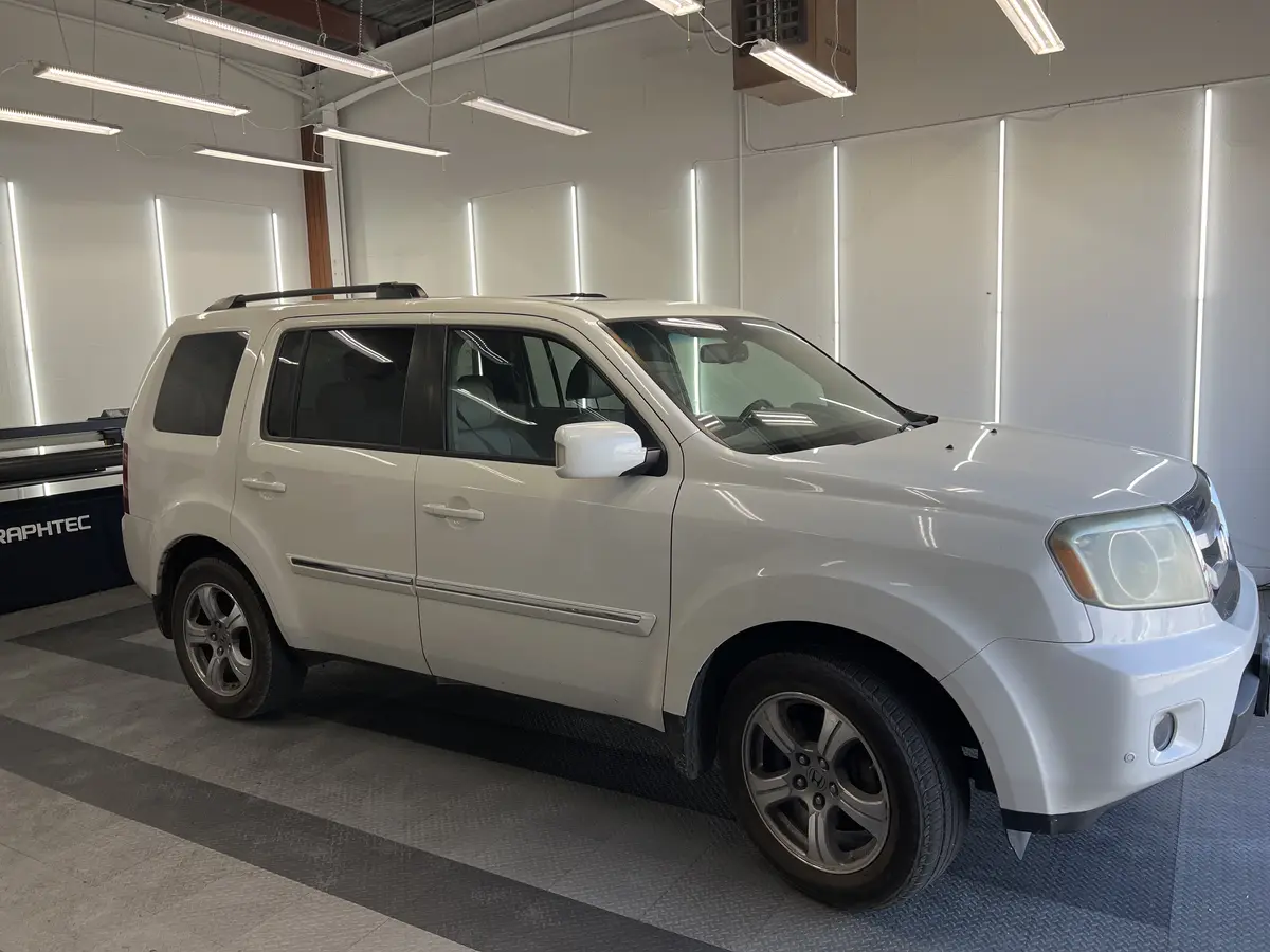 White Honda Pilot before window tinting, factory glass (view 1)