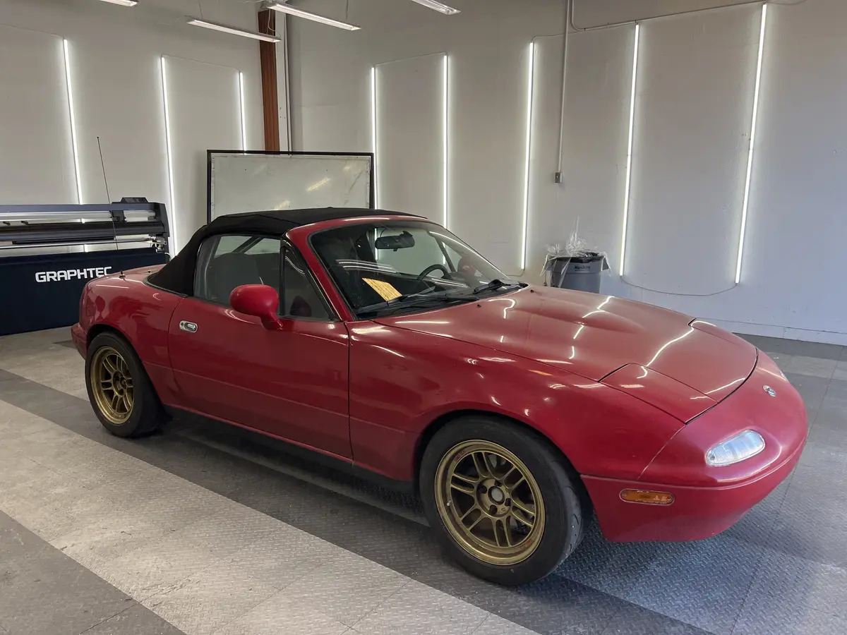 Red Mazda MX-5 Miata before window tinting, factory glass (view 1)