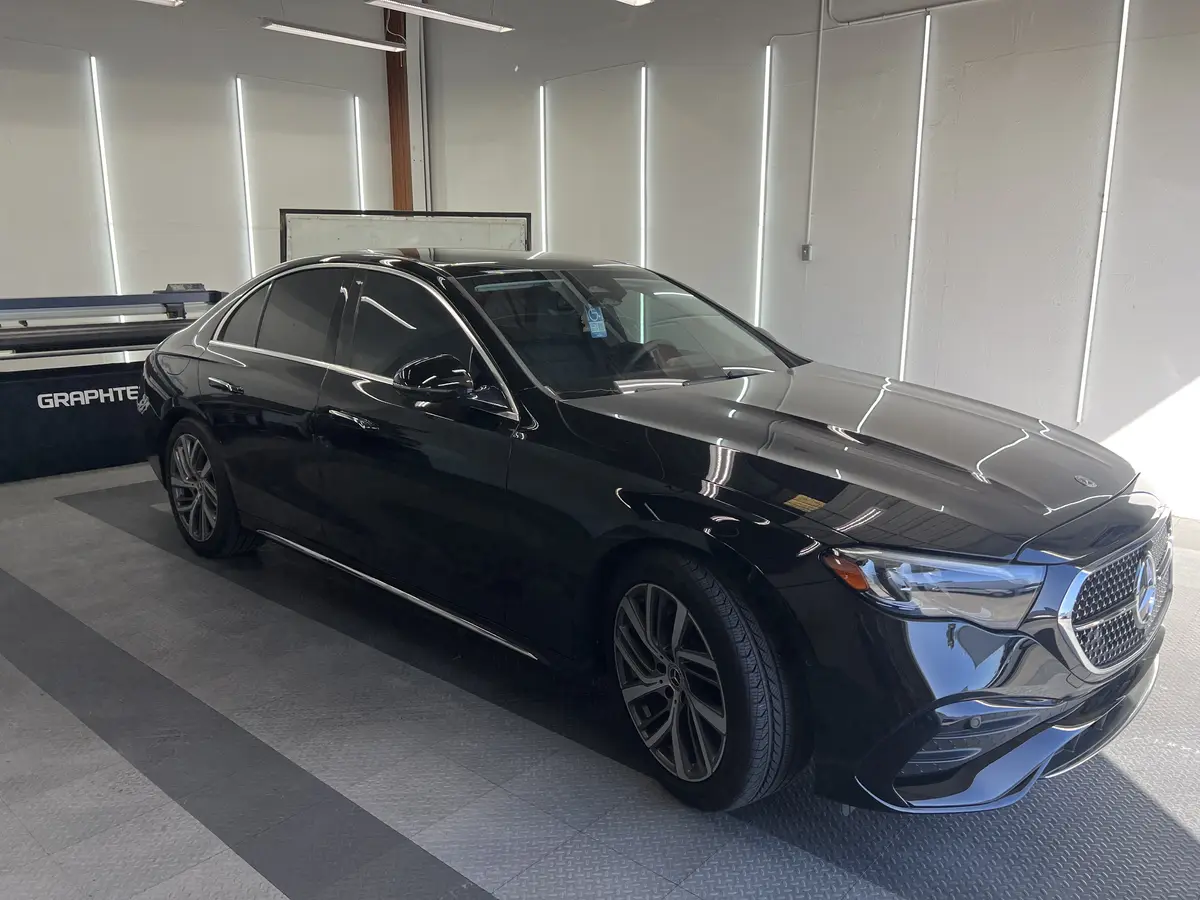 Black Mercedes-Benz E-Class before window tinting, factory glass (view 1)