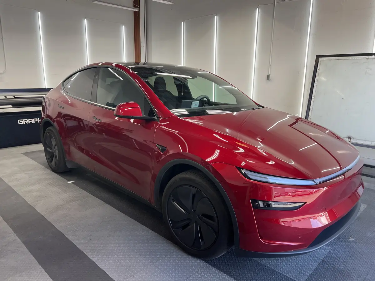 Red Tesla Model Y before window tinting, factory glass (view 1)