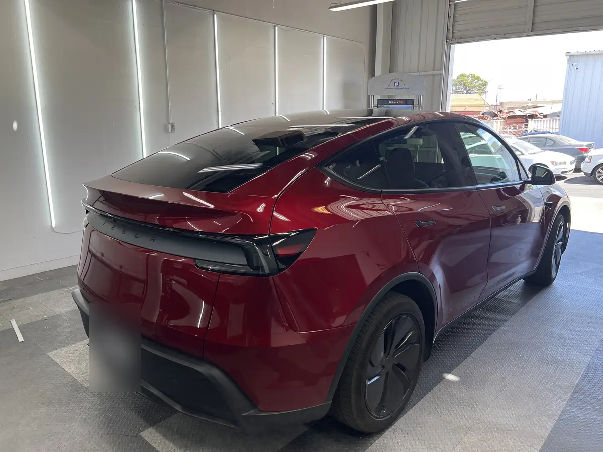 Red Tesla Model Y before window tinting, factory glass (view 3)