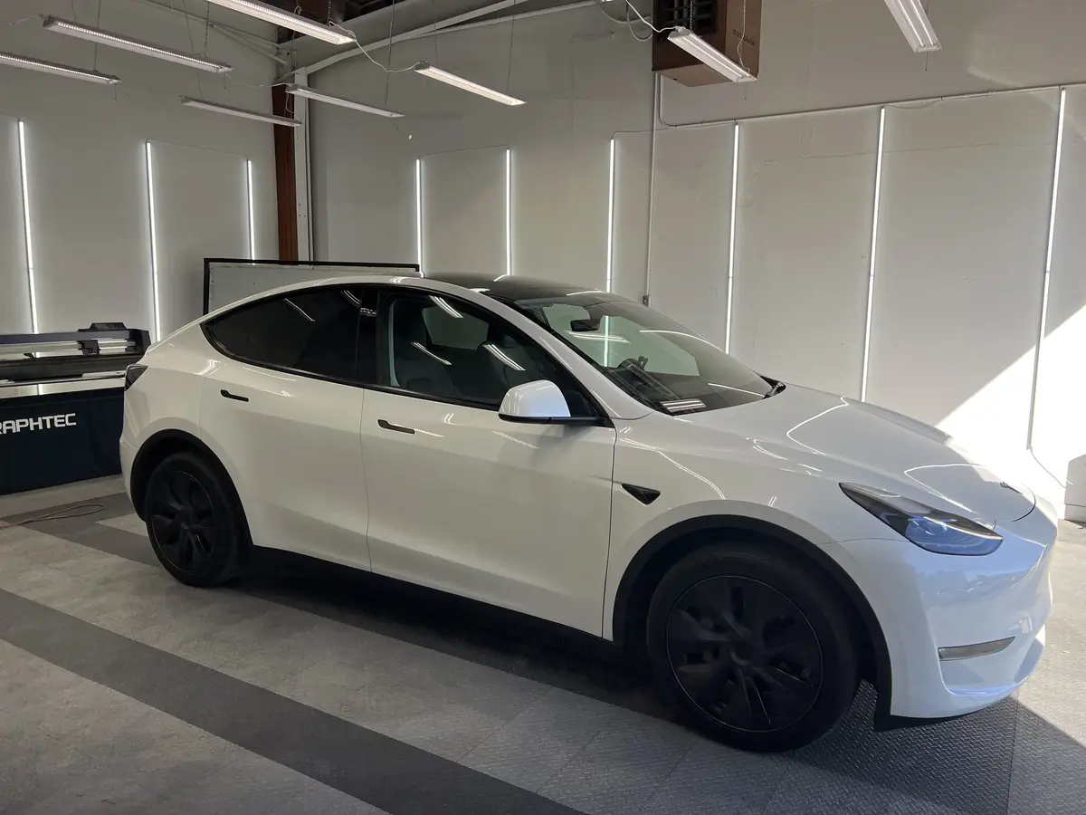 White Tesla Model Y before window tinting, factory glass (view 1)
