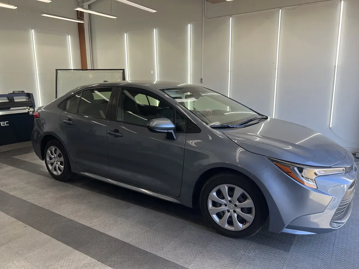 Gray Toyota Corolla before window tinting, factory glass (view 1)
