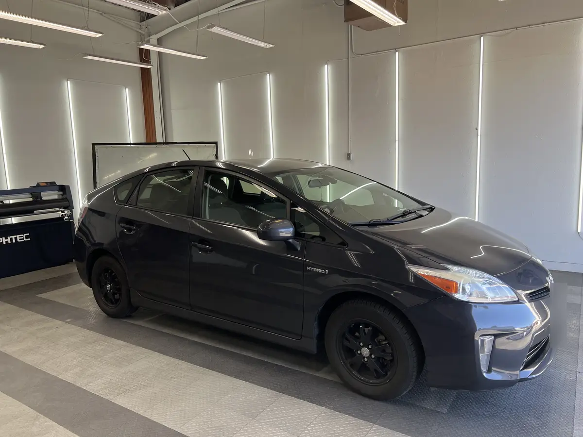 Gray Toyota Prius before window tinting, factory glass (view 1)