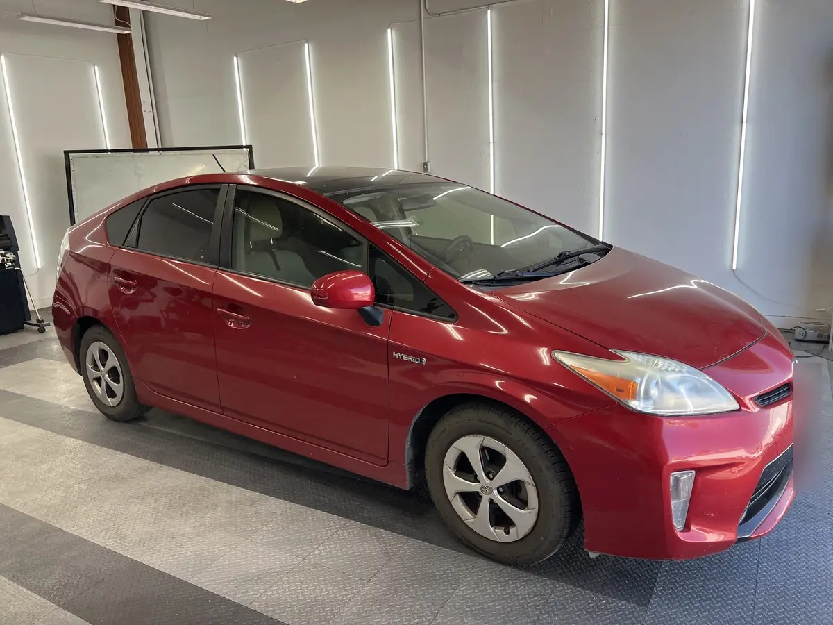 Red Toyota Prius before window tinting, factory glass (view 1)