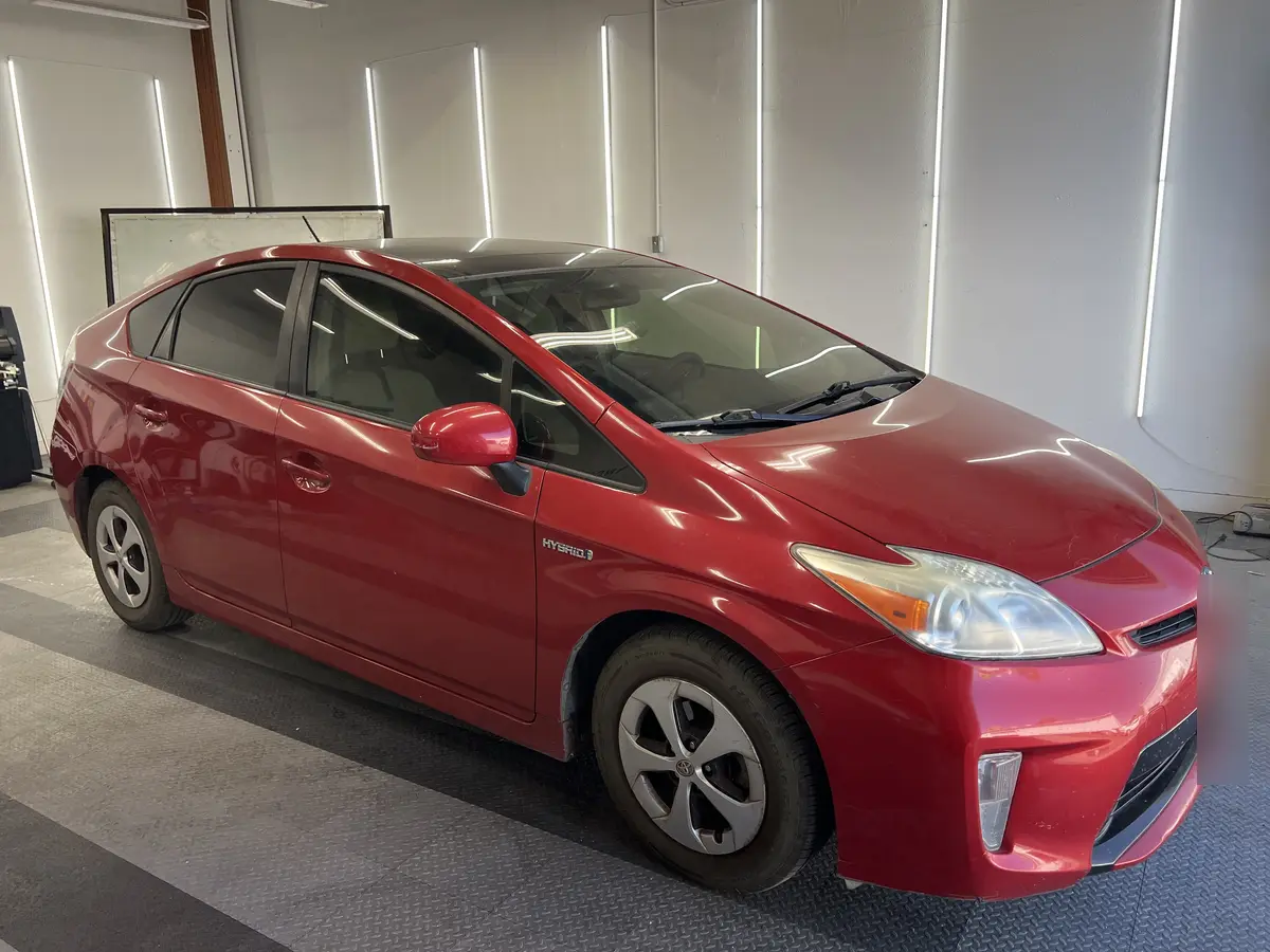 Red Toyota Prius before window tinting, factory glass (view 2)