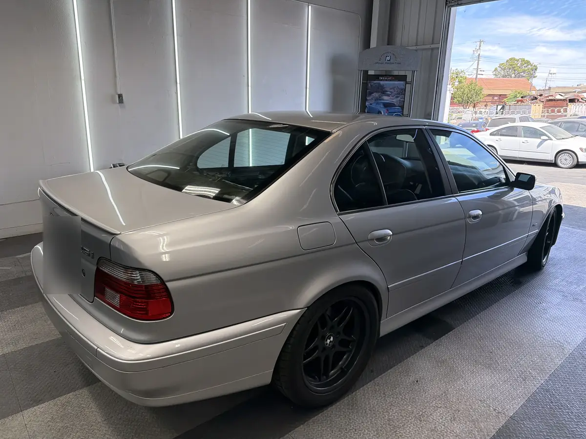 Silver BMW 5 Series before window tinting, factory glass (view 3)