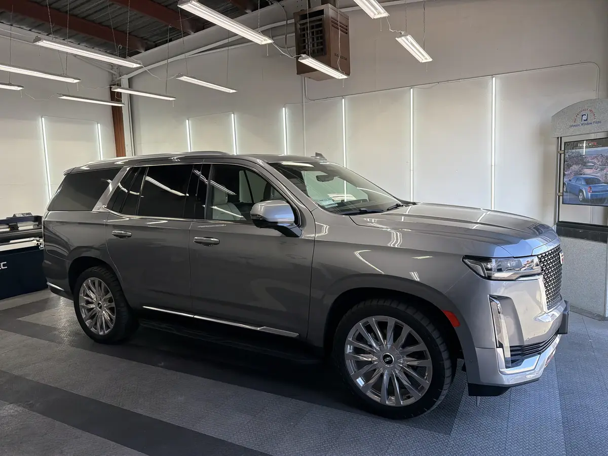 Gray Cadillac Escalade before window tinting, factory glass (view 1)