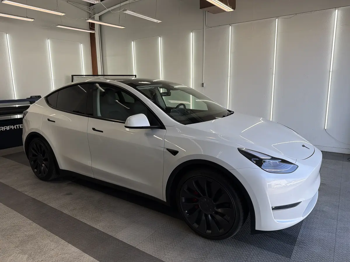 White Tesla Model Y before window tinting, factory glass (view 1)