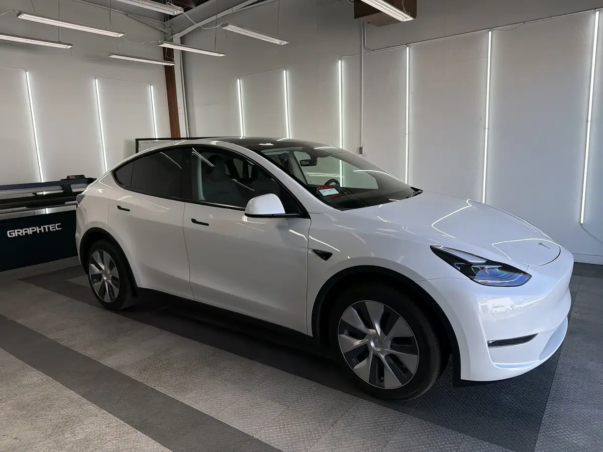 White Tesla Model Y before window tinting, factory glass (view 1)