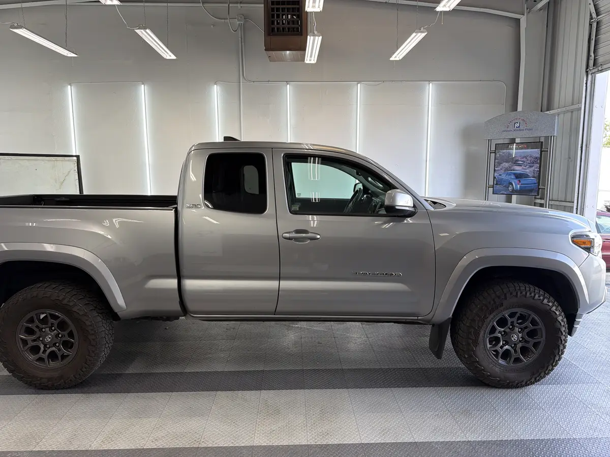 Silver Toyota Tacoma before window tinting, factory glass (view 2)